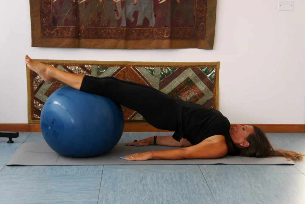 Esercizio a terra con le gambe appoggiate su un pallone da ginnastica