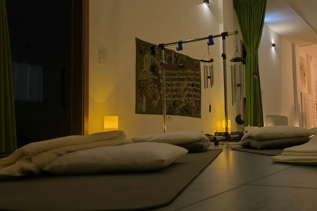 Cuscini e coperte nella sala di Premadevi Shala, alla luce delle candele